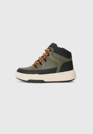 Chaussure mi-montante verte avec accents noirs, lacets orange, semelle en caoutchouc texturée et détails en cuir lisse. Présente un bout rond et une conception robuste.