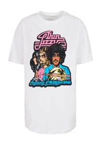 Balta medvilnė marškinėliai su ryškiu retro grafiniu piešiniu, vaizduojančiu tris figūras ir užrašu "Thin Lizzy Vagabond of the Taylor World."