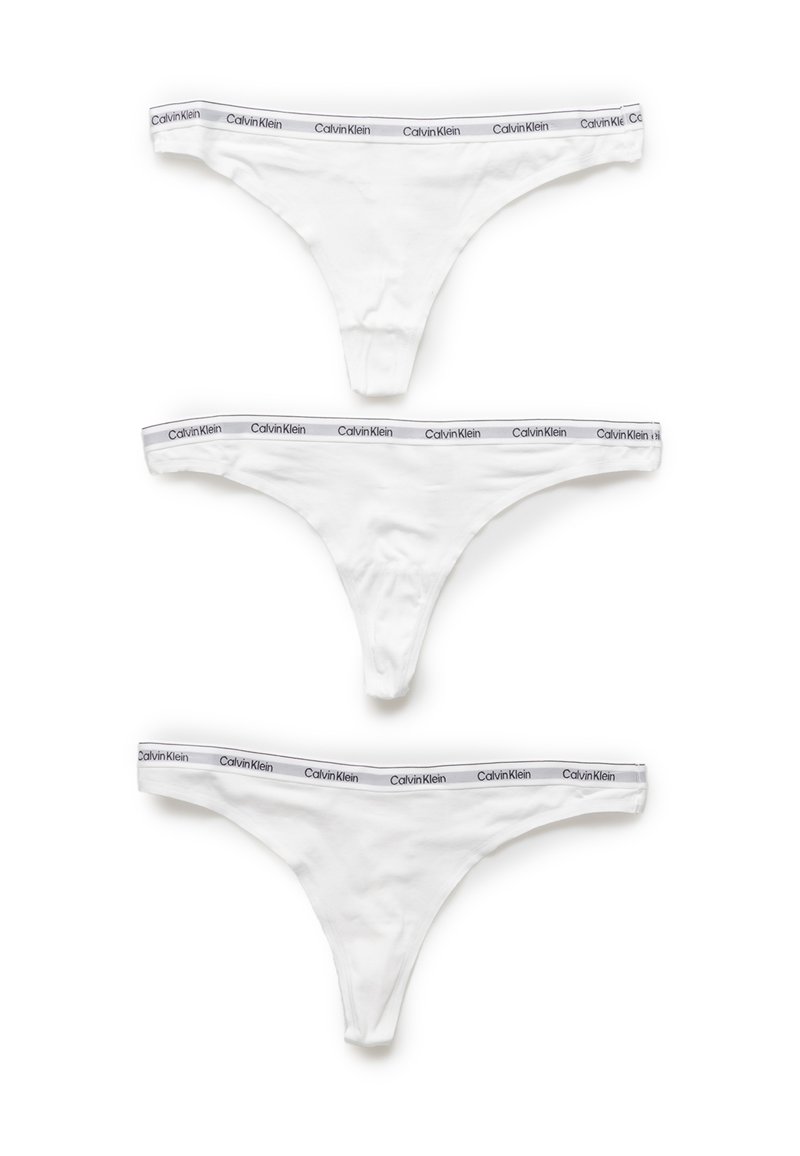 Drie witte katoenen strings met grijze Calvin Klein logo tailleband, die een gladde textuur en minimalistisch ontwerp tonen.