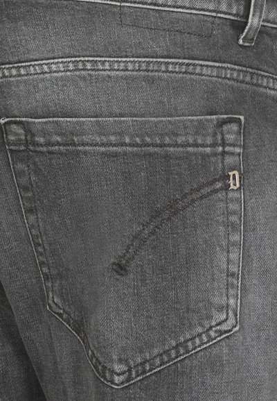 I jeans in denim grigio presentano una tasca posteriore con un design curvo unico e un piccolo accento metallico. Il tessuto ha una sottile trama.