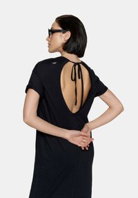 Czarna bawełniana sukienka z głębokim, otwartym dekoltem z wiązaniem, krótkimi rękawami i luźnym krojem, prezentująca gładką fakturę.