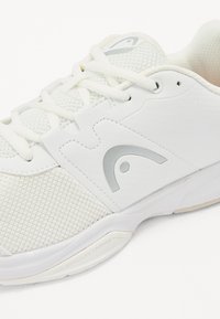 Weißer Sportschuh mit einem Obermaterial aus Mesh, glatten Akzenten, silbernen Details und einer strukturierten Sohle mit eingravierter Aufschrift "STABILITY TRIGGER".