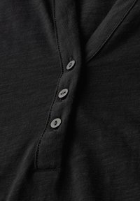 Černé tričko Henley s knoflíkovou légou a čtyřmi odpovídajícími knoflíky, vyrobené z měkké texturované tkaniny.