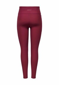 Burgundy leggings med hög midja och elastiskt material. Slät yta, figurnära design, inga synliga mönster eller detaljer.