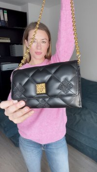 Borsa a tracolla in pelle nera trapuntata con una tracolla in catena dorata e un'edizione con logo. Presenta un motivo testurizzato sulla parte anteriore. Misura circa 20x13 centimetri.