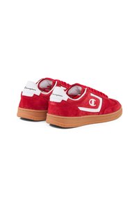 Sneaker in suede rosso con tocchi bianchi, lacci rotondi e suola in gomma. Presenta il logo di lato e un tallone testurizzato per la presa.