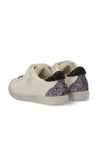 Zapatillas de velcro en cuero crema con acabado texturizado. Detalles brillantes en negro y plata en el talón, suela de goma plana.