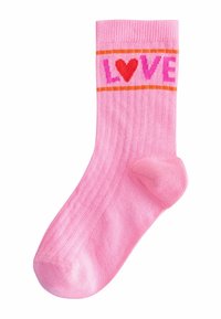 Rozā zeķe ar sarkanu sirdi un rozā burtiem, kas veido vārdu "LOVE", apmales ar divām plānām oranžām līnijām pie augšas.