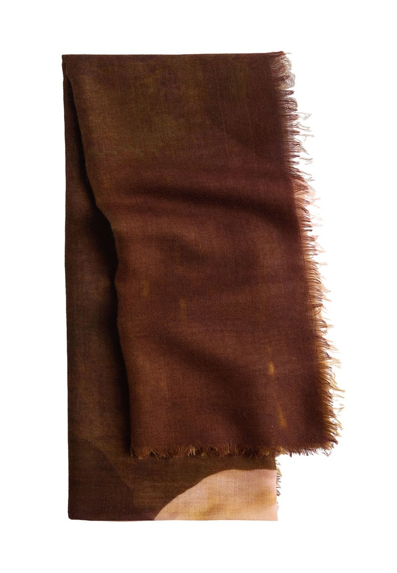 Brązowy, pleciony szal z postrzępionymi krawędziami, prezentujący gradient od ciemnego brązu do jaśniejszych odcieni. Miękka tekstura i warstwowy design.