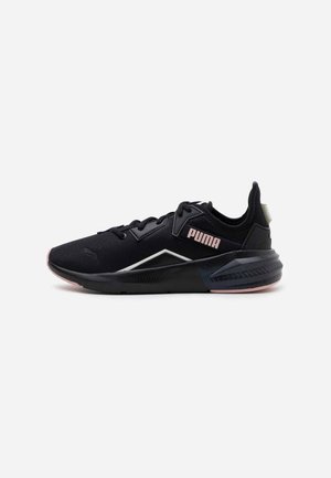 Chaussure de sport noire Puma avec profil bas, lacets, semelle coussinée et logo Puma rose sur le côté.