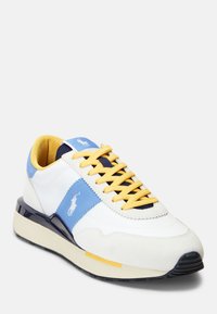 Vita sneakers med blåa och gula detaljer, tillverkade av mocka och läder, rund tå, texturerad sula, med varumärkeslogotyp på sidan och tungan.