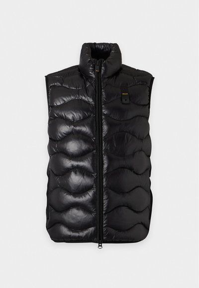Chaleco negro brillante acolchado sin mangas con cremallera frontal y pequeño detalle de bolsillo en el pecho sobre fondo blanco.