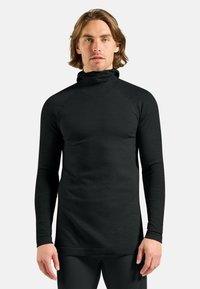 Black long-sleeve turtleneck with a textured, ribbed design. Features raglan sleeves and a fitted silhouette, suitable for layering.