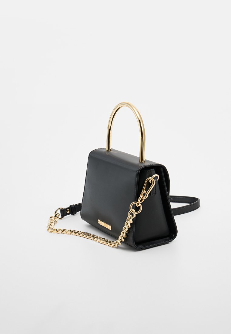 Schwarze Lederhandtasche mit einem goldenen Metallgriff, Kettenriemen und strukturiertem Design. Mit einem Logo-Detail auf der Vorderseite.