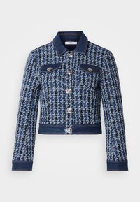 Veste en tweed bleu avec des accents en denim, dotée d'un col classique, de deux poches poitrine et de boutons argentés. Tissu texturé avec un motif dessiné.