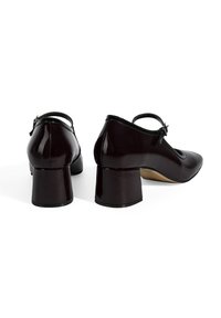 Chaussures noires en cuir verni avec un talon carré et une bride de cheville, présentant un bout rond et un design épuré.