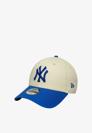 Cappellino da baseball beige e blu dei New York Yankees con logo ricamato e visiera curva, mostrato leggermente inclinato su sfondo bianco.