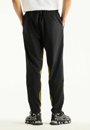 New Balance, UTILITY STRETCH WOVEN PANT - Pantaloni sportivi - sport green black