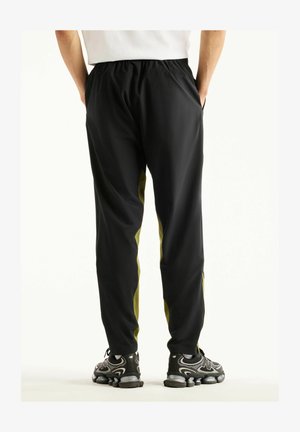 New Balance, UTILITY STRETCH WOVEN PANT - Pantaloni sportivi - sport green black