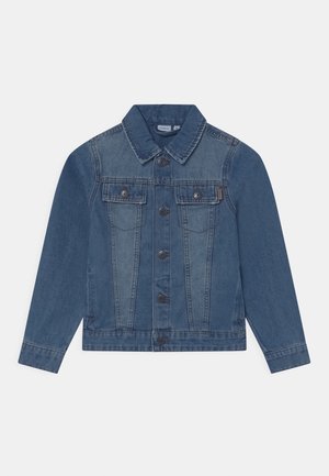 Denimjakke i mellemblå med knapper foran, to brystlommer og en klassisk krave. Har en lysere nuance på den øverste halvdel.