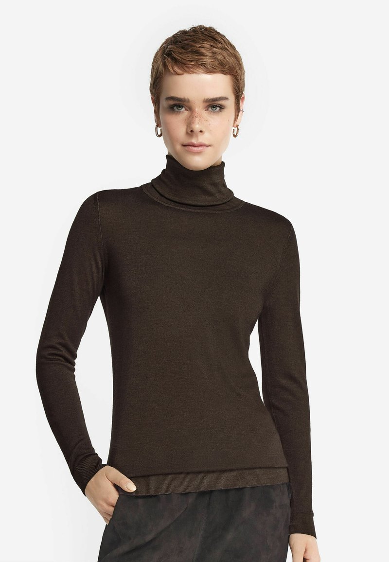 Brun polotröja i ett mjukt, stretchigt material, med långa ärmar och en åtsittande design, i kombination med en texturerad svart underdel.
