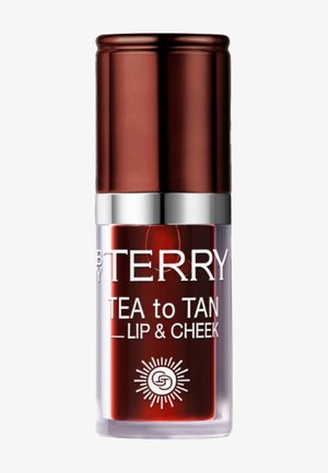 By Terry Tea to Tan lip- en cheek tint in een doorzichtige tube met een metalen bronzen dop en witte bedrukte branding.