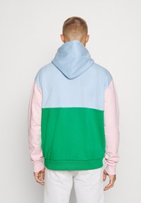 Felpa con cappuccio caratterizzata da blocchi di colore blu chiaro, rosa e verde. Realizzata in materiale morbido con polsini e orlo a costine.