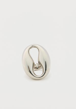 Anello ovale argentato lucido con un design spesso e intrecciato e un centro cavo, mostrato su uno sfondo bianco semplice.