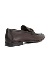 Brown leather loafer with a low profile, square toe, and accent stitching. Features a metal hardware detail and textured sole.