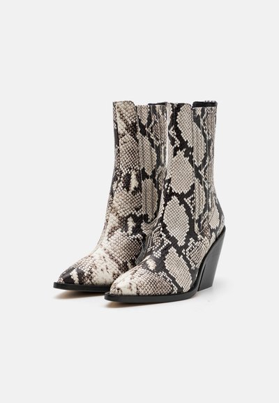 Pointed-toe ankle boots in a black and white snake print pattern, made from faux leather. Features a tapered wedge heel and minimal stitching.