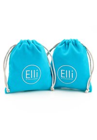 To kridhavede snoreposer lavet af blødt stof i turkise nuancer, med et hvidt rundt logo, der har teksten "Elli" og "by Julie & Grace".