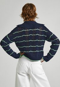 Navy knitted sweater with a large collar, featuring green and white horizontal stripes, intricate lace patterns, and ribbed hem and cuffs.