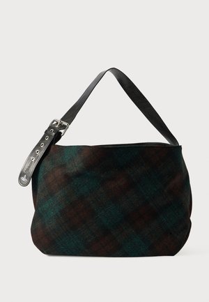 Tamsiai žalia ir ruda languota petinė rankinė su plačia juoda reguliuojama juosta ir sidabriniu užsegimu prieš paprastą šviesią fono.