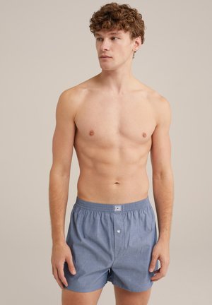 Boxers de algodón azul claro con una cinturilla elástica, una bragueta de un solo botón y una textura suave. Sin patrones ni acentos adicionales visibles.