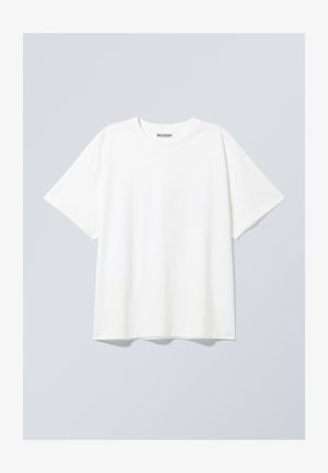 Valge puuvillane T-särk lõdva lõikega, lühikeste varrukatega ja ümmarguse kaelusega. Kaeluses on diskreetne brändi silt.