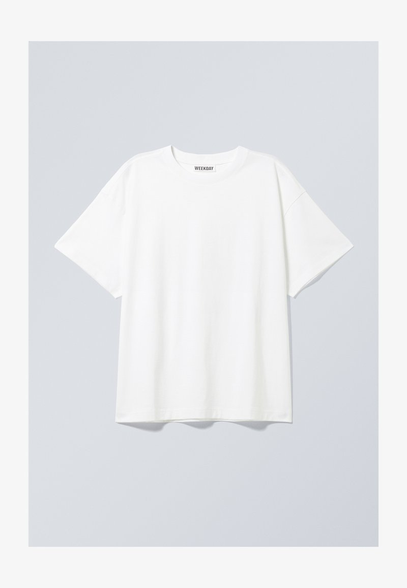 Λευκό βαμβακερό T-shirt με χαλαρή εφαρμογή, κοντά μανίκια και στρογγυλή λαιμόκοψη. Διαθέτει μια διακριτική ετικέτα μάρκας στη λαιμόκοψη.