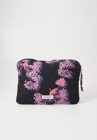Quiltad svart tygpåse med rosa och lila blommönster, dragkedjestängning och en dekorativ dragring. Har en liten logotypetikett.