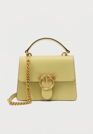 Bolso rectangular de color verde claro con asa superior, correa de cadena dorada y cierre en forma de pájaro dorado en la solapa frontal.