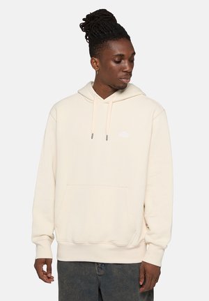 Sudadera color crema fabricada en tejido suave, con bolsillo frontal, capucha ajustable y un pequeño logo en el pecho.