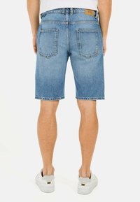Denim shorts i lyseblå, med lige pasform, to baglommer og et lædermærke på taljen. Blød, slidt tekstur.