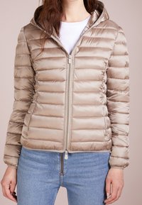 Beige Puffy-Jacke mit Reißverschluss und Kapuze. Gestepptes Design mit glatter Textur. Verfügt über elastische Bündchen und einen leicht verkürzten Schnitt.