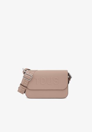 Sac à bandoulière rose pâle avec une surface texturée, présentant un logo "TOUS" en relief et une sangle réglable avec des accents de logo.