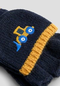 Navy siniset käsineet, joissa on keltainen ribbikuvio, jossa on brodeerattu keltainen traktori ja siniset pyörät -kuvio. Teksturoitu villa materiaali.