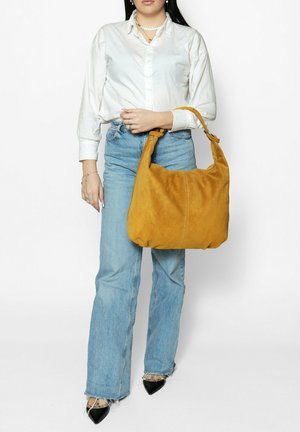 Borsa hobo in camoscio giallo senape con una singola tracolla e forma morbida e arrotondata. Design leggero adatto all'uso casual.