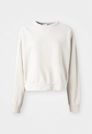 Cream-colored cropped sweatshirt made of soft fabric, featuring a round neckline, long sleeves, and an embroidered logo on the chest.