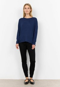 Navy long-sleeve top with a loose fit and wide neckline, paired with black fitted pants and black flats. Simple and minimal design.