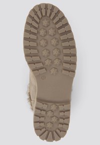 Semelle de botte en caoutchouc beige avec motifs texturés hexagonaux et étoiles, dotée d'une semelle extérieure plate et d'une légère bande de roulement surélevée pour l'adhérence.