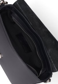 Zwarte leren schoudertas met zilverkleurige hardware, voorzien van een ritsvak aan de binnenkant en een zachte suède voering.