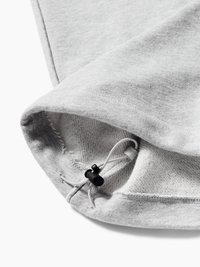 Κοντινή λήψη γκρι υφάσματος με ρυθμιζόμενο κορδόνι και μαύρο στοπ, που δείχνει υφή πλέξης και λεπτομέρειες ραφής.