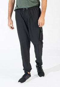 Zwarte cargobroek met een elastische tailleband, zijzakken en enkelsluiting. Gemaakt van een lichte stof met een subtiele glans.